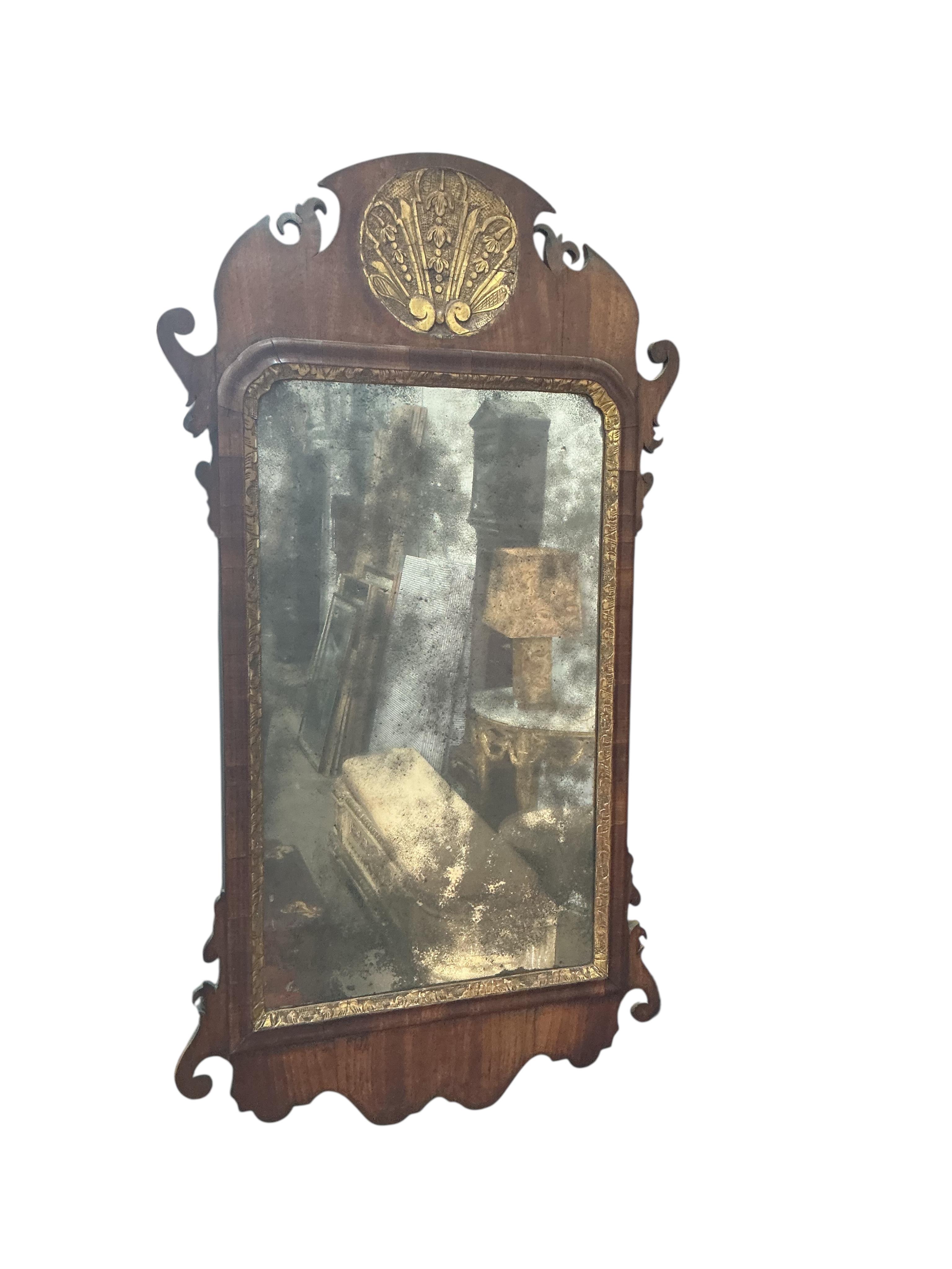 A walnut and parcel gilt fret cut mirror, width 46cm, height 86cm